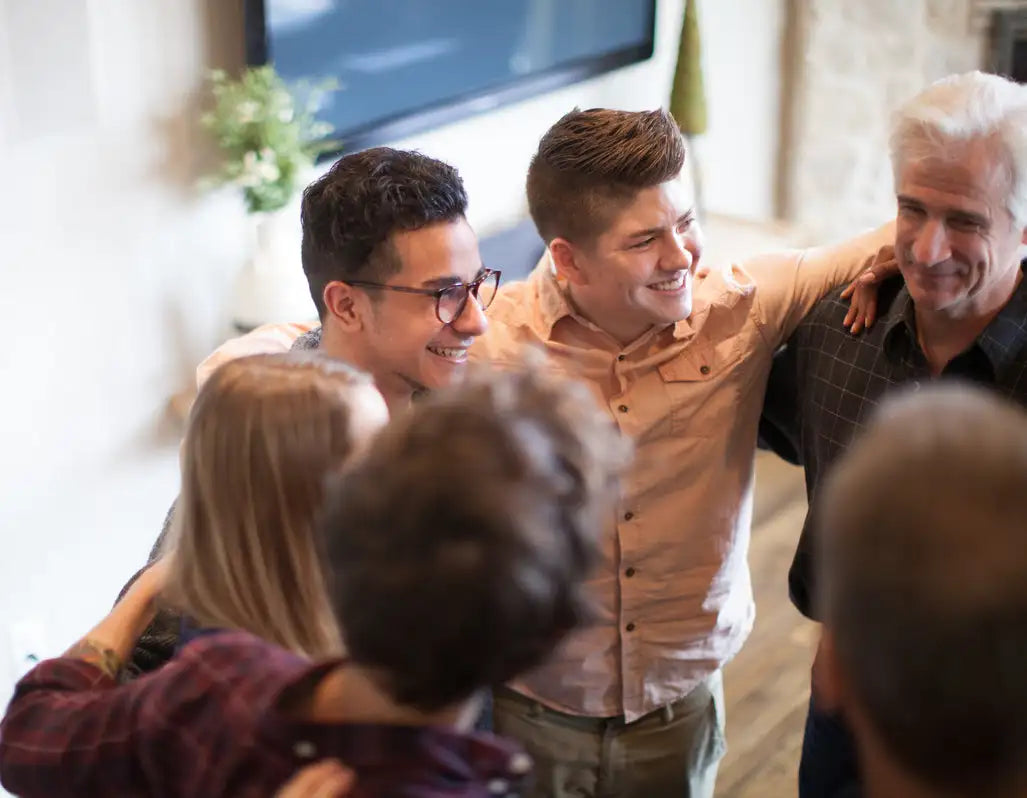 A beige button-up shirt worn by a smiling young man in the center of a group.