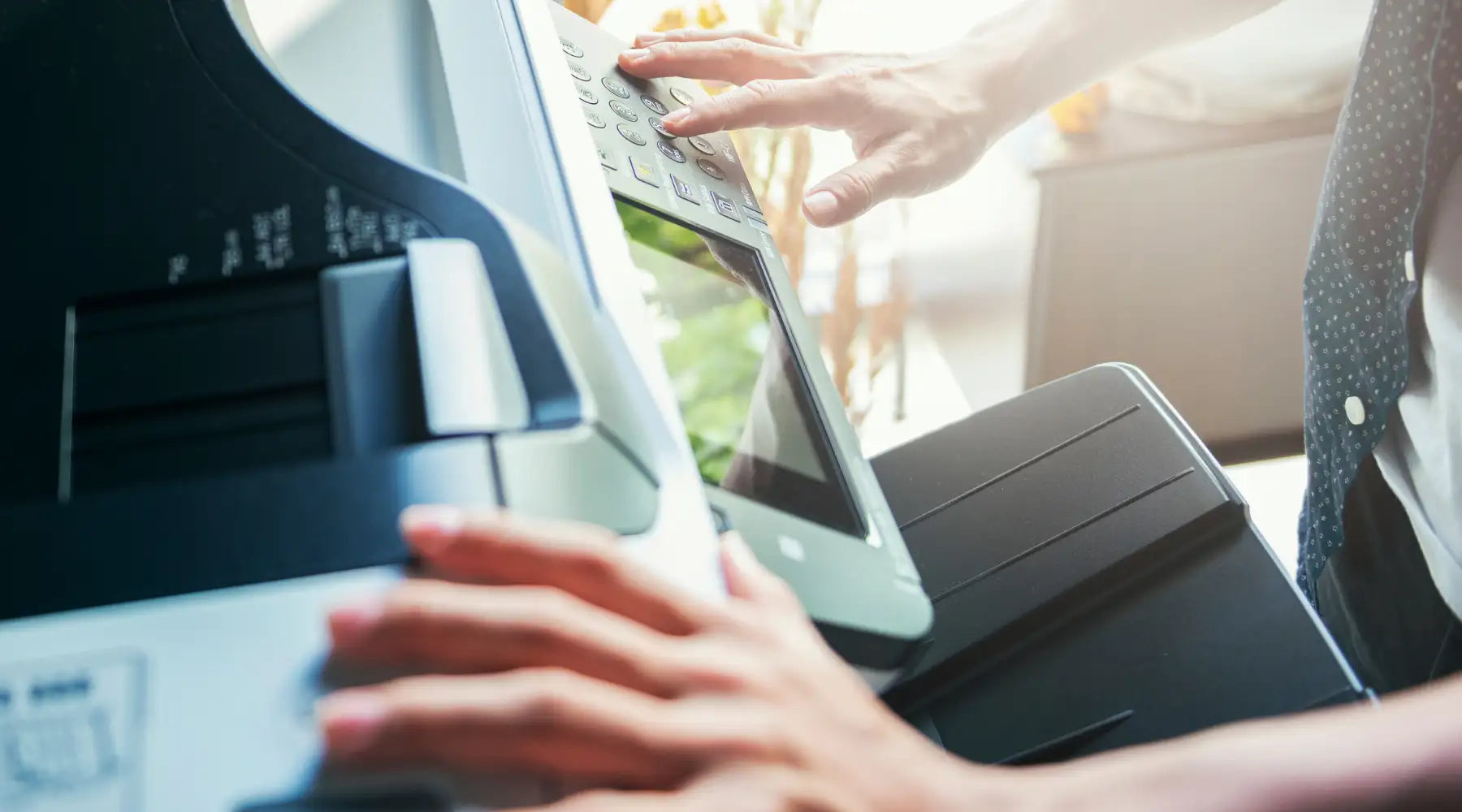 Black and gray multifunction printer with a touchscreen display and numeric keypad.