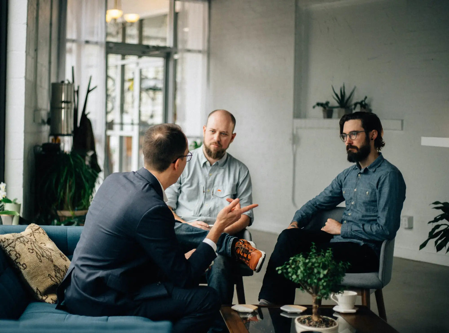 Blue upholstered sofa with a patterned throw pillow