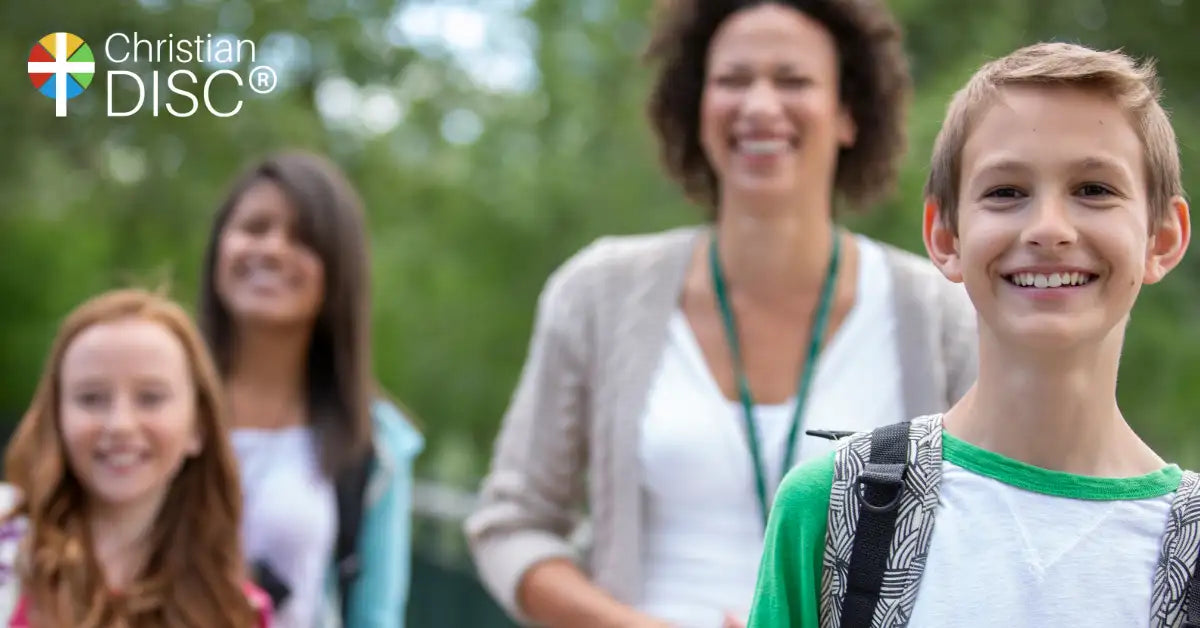 A smiling boy wearing a green and white shirt with black patterned backpack straps.