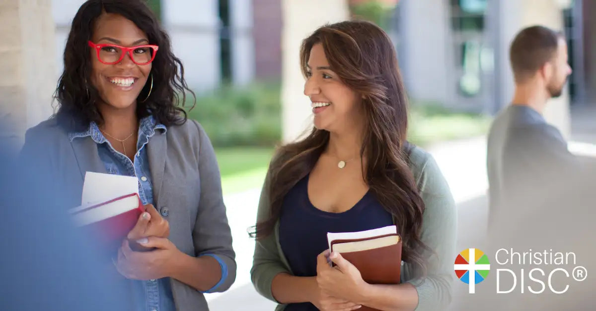 Red-framed glasses worn by a smiling woman with dark curly hair.