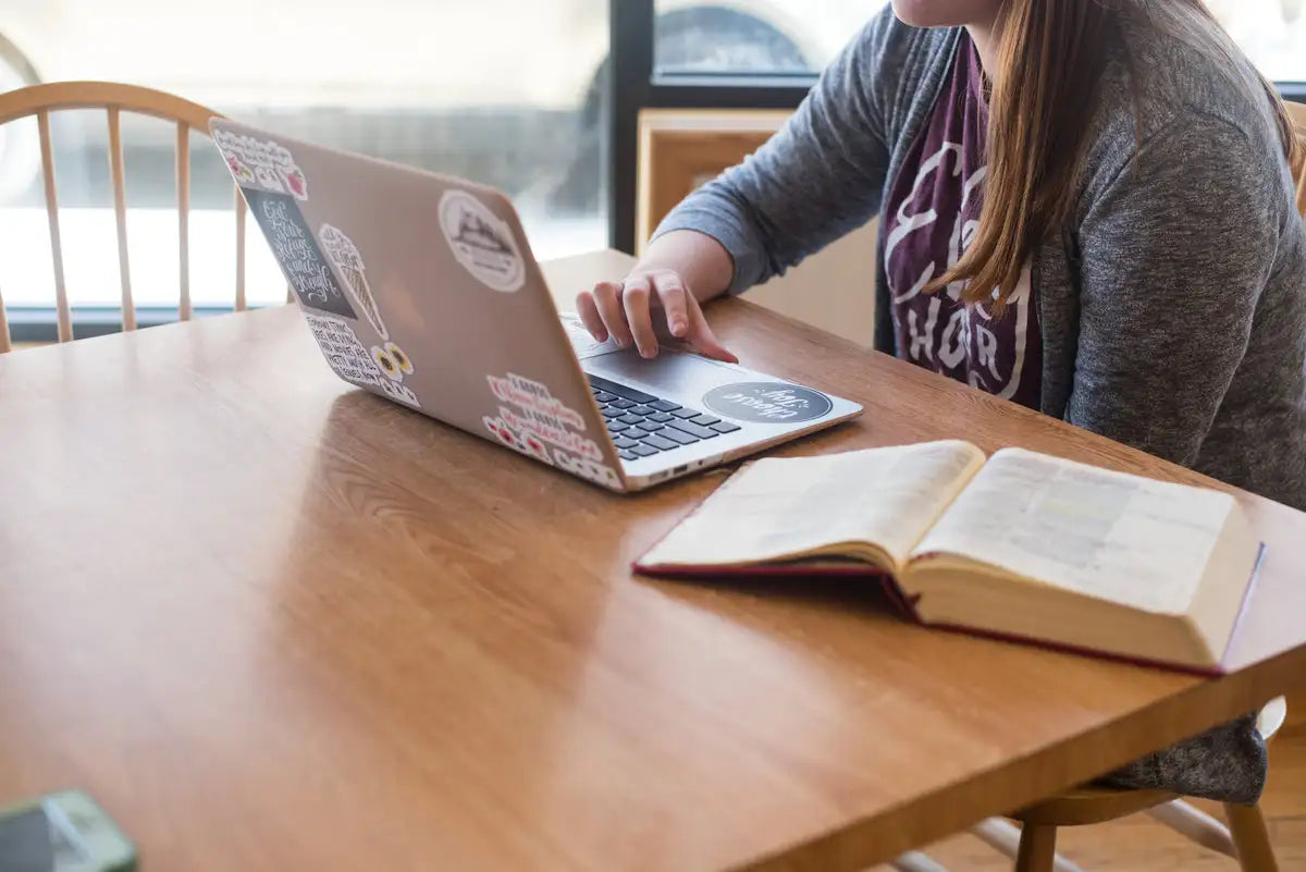 Silver laptop adorned with various colorful stickers.