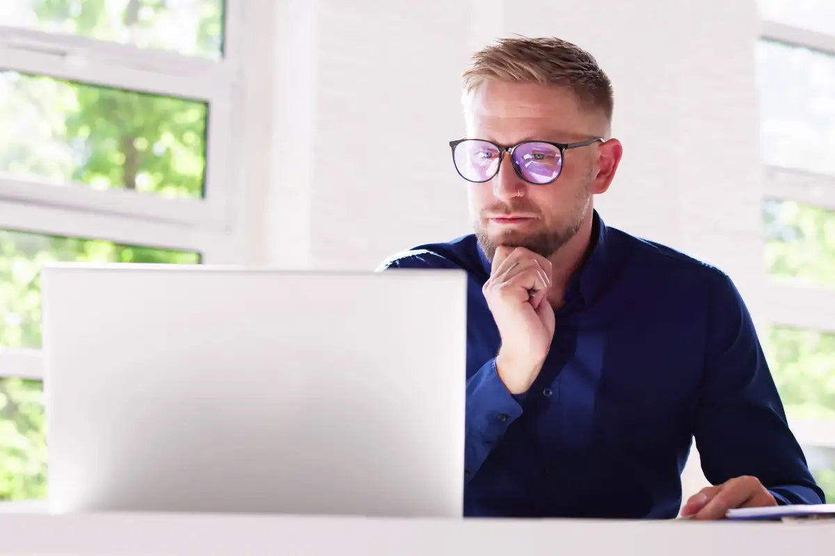 A sleek silver laptop with a minimalist design sits open on a desk.