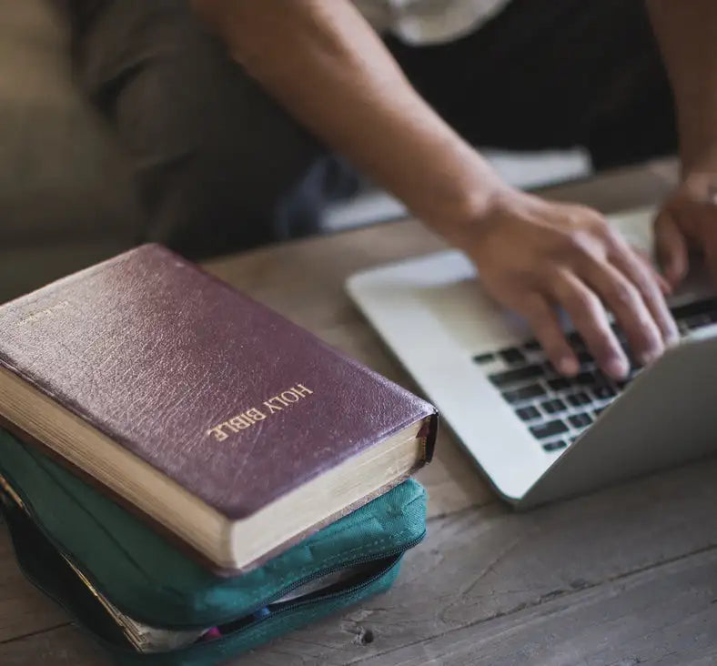 A worn, burgundy leather-bound holy bible with gold lettering on the cover.
